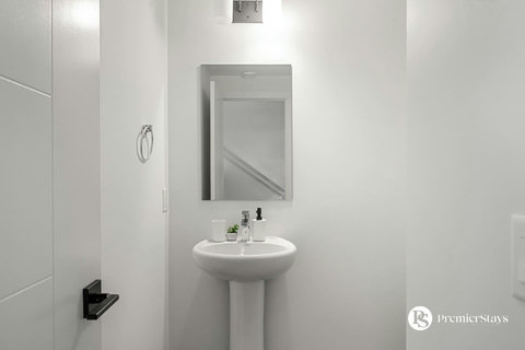 Bright and airy bathroom with pedestal sink and convenient amenities