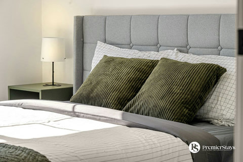 Stylish bedroom featuring a comfortable bed with decorative pillows and bedside lamp