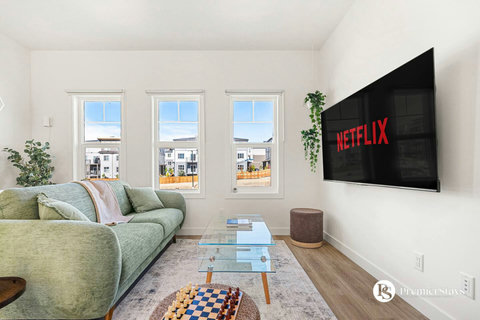 Bright living room with smart TV and expansive windows overlooking the neighborhood