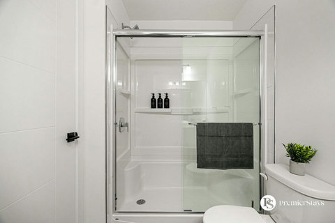 Spa-like walk-in shower with sleek glass doors and convenient built-in storage
