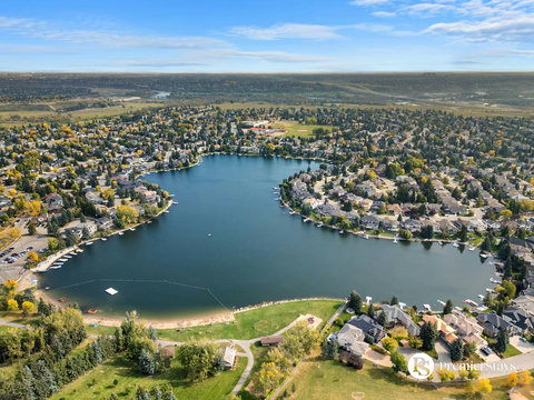 Stunning aerial view of serene lakefront living with tree-lined shores and waterfront homes