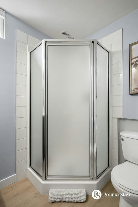 Clean modern bathroom featuring a spacious corner shower with frosted glass doors