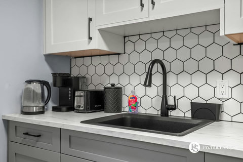 Sleek kitchen equipped with modern appliances and stylish hexagonal backsplash