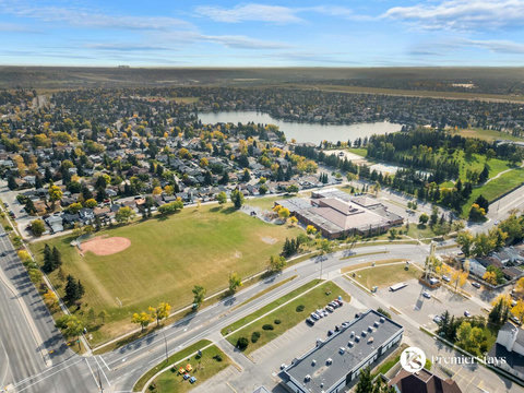 Stunning aerial perspective showcasing the vibrant community, sparkling lake, and lush surroundings