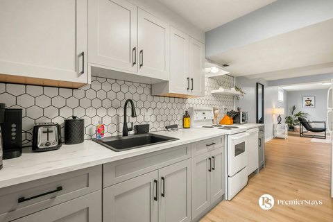 Fully equipped modern kitchen with white cabinetry and stylish hexagonal backsplash