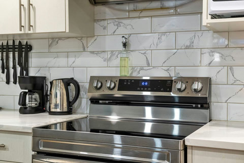 Fully equipped modern kitchen with stainless steel appliances and elegant marble tilework