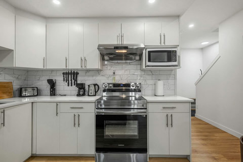 Fully equipped modern kitchen with stainless steel appliances and marble backsplash