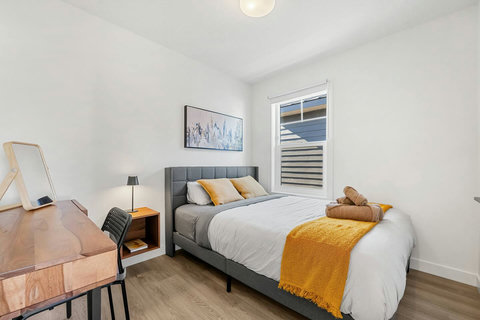 Comfortable guest bedroom with modern furnishings and natural light