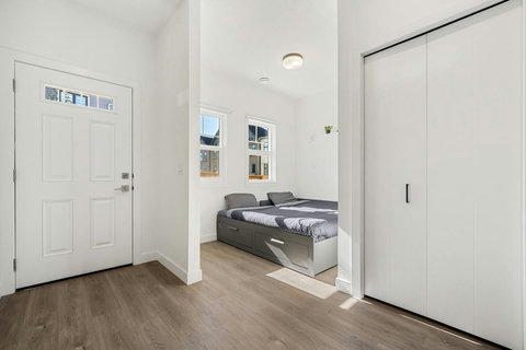 Comfortable guest bedroom flooded with natural light and urban views
