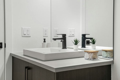 Sleek dual-sink bathroom with contemporary black fixtures and plenty of counter space
