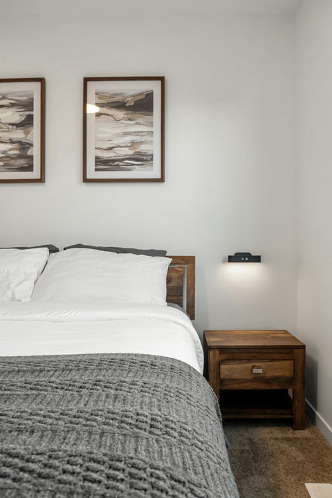 Comfortable guest bedroom with warm wood accents and curated wall art