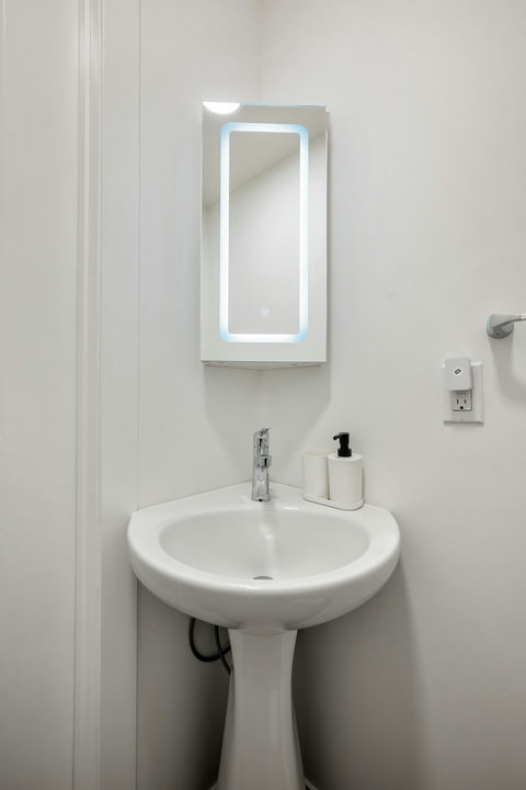 Sleek half bath featuring LED-lit mirror and contemporary fixtures