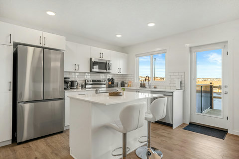 Bright modern kitchen featuring stainless steel appliances and island seating
