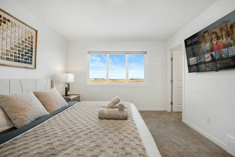 Bright main bedroom with stunning views and modern entertainment setup