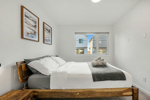 Comfortable guest bedroom with natural light and modern furnishings throughout