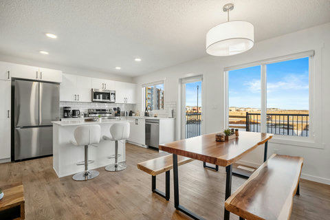 Sleek kitchen flows into dining area with stunning landscape views