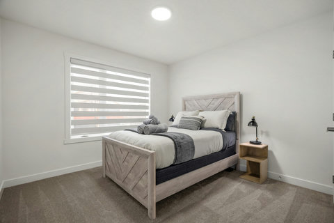 Light-filled bedroom with stylish wooden bed and contemporary decor
