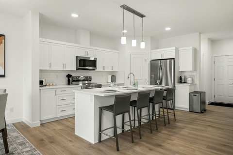 Stylish contemporary kitchen featuring stainless steel appliances and spacious island