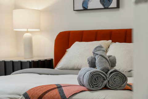 Inviting guest bedroom with warm orange headboard and plush bedding