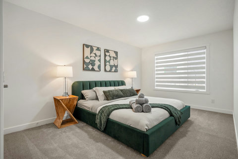 Stylish master bedroom featuring a plush green bed and curated artwork