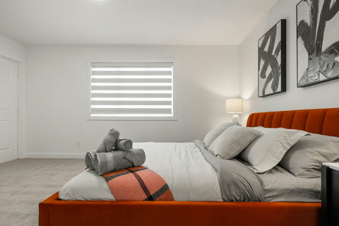 Stylish guest bedroom with burnt orange headboard and crisp white bedding