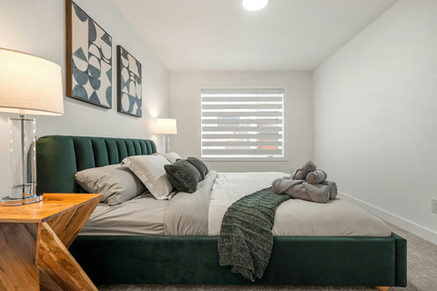 Stylish guest bedroom featuring a contemporary green bed and plenty of natural light