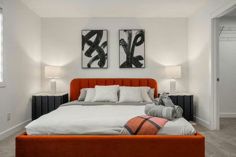 Stylish master bedroom featuring a bold orange headboard and curated black and white art