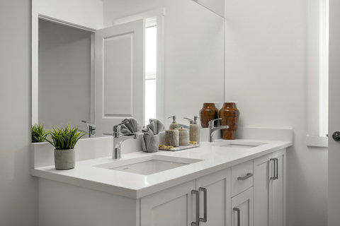Spacious dual vanity bathroom with elegant white finishes and natural light