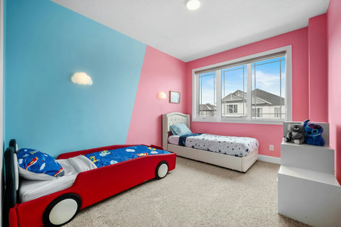 Kids will love this vibrant bedroom with a fun race car bed and twin beds