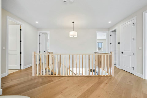 Airy upper landing with beautiful wood railings connecting all bedrooms