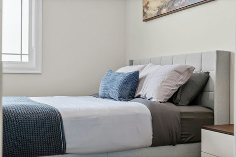A fresh, functional bedroom with a blue accent wall and personal workspace