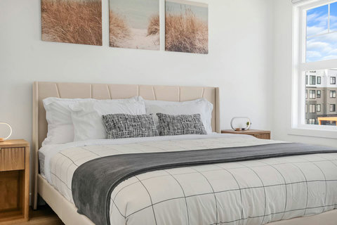 Serene guest bedroom with comfortable upholstered bed and urban views