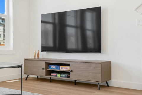 Stylish living room featuring wall-mounted flat-screen TV and mid-century modern entertainment center