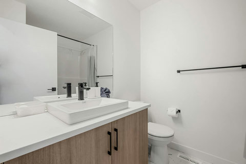 Sleek modern bathroom featuring dual vanity sinks and glass shower enclosure