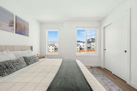 Spacious master bedroom flooded with natural light and city views