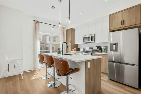 Bright modern kitchen with stainless steel appliances and seating