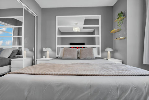 Stylish master bedroom with custom shelving and integrated entertainment center