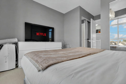 Comfortable master bedroom featuring smart TV and stunning ocean views.