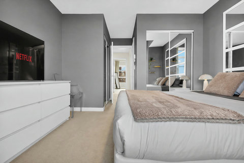 Stylish master bedroom featuring smart TV and contemporary furnishings throughout