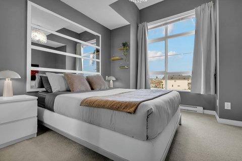 Spacious master bedroom filled with natural light and stunning city views