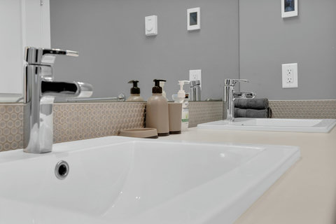 Sleek master bath featuring dual vanities and premium chrome fixtures