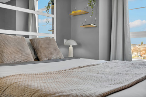 Bright contemporary bedroom flooded with natural light and views