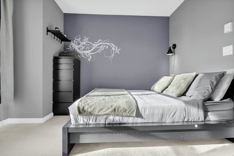 Stylish bedroom featuring a calming purple accent wall and contemporary design
