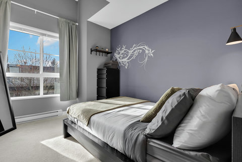 Stylish bedroom featuring purple walls and abundant natural light throughout