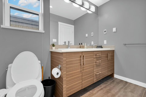 Spa-like master bath featuring dual vanity and warm wood finishes