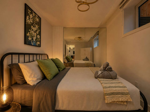 Intimate guest bedroom with stylish black bed and warm lighting