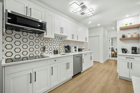 Bright, chef-ready kitchen featuring geometric backsplash and stainless appliances