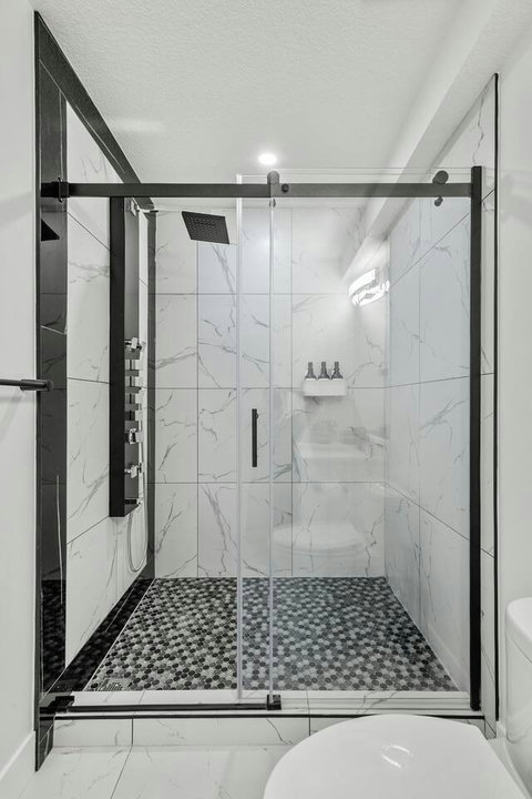 Luxurious walk-in shower with marble accents and modern rainfall showerhead