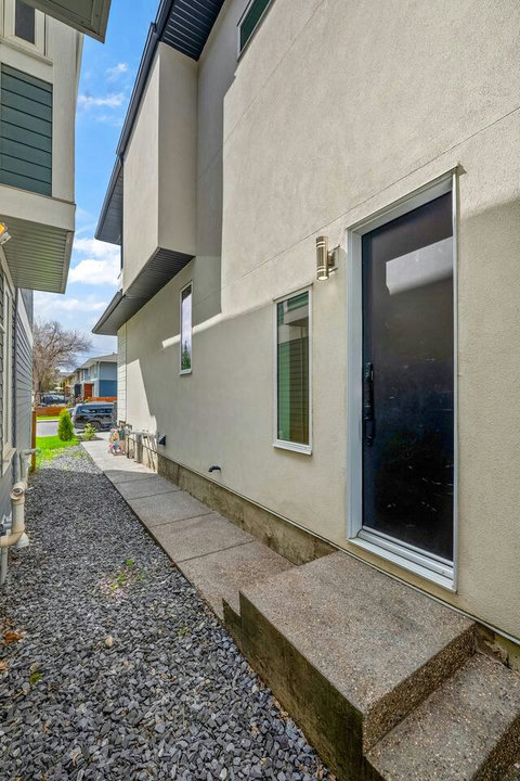 Sleek side entrance with modern design and clean landscaping
