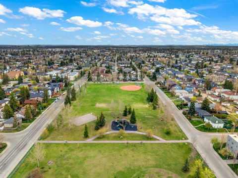 Tree-lined community park featuring a baseball diamond and playground equipment